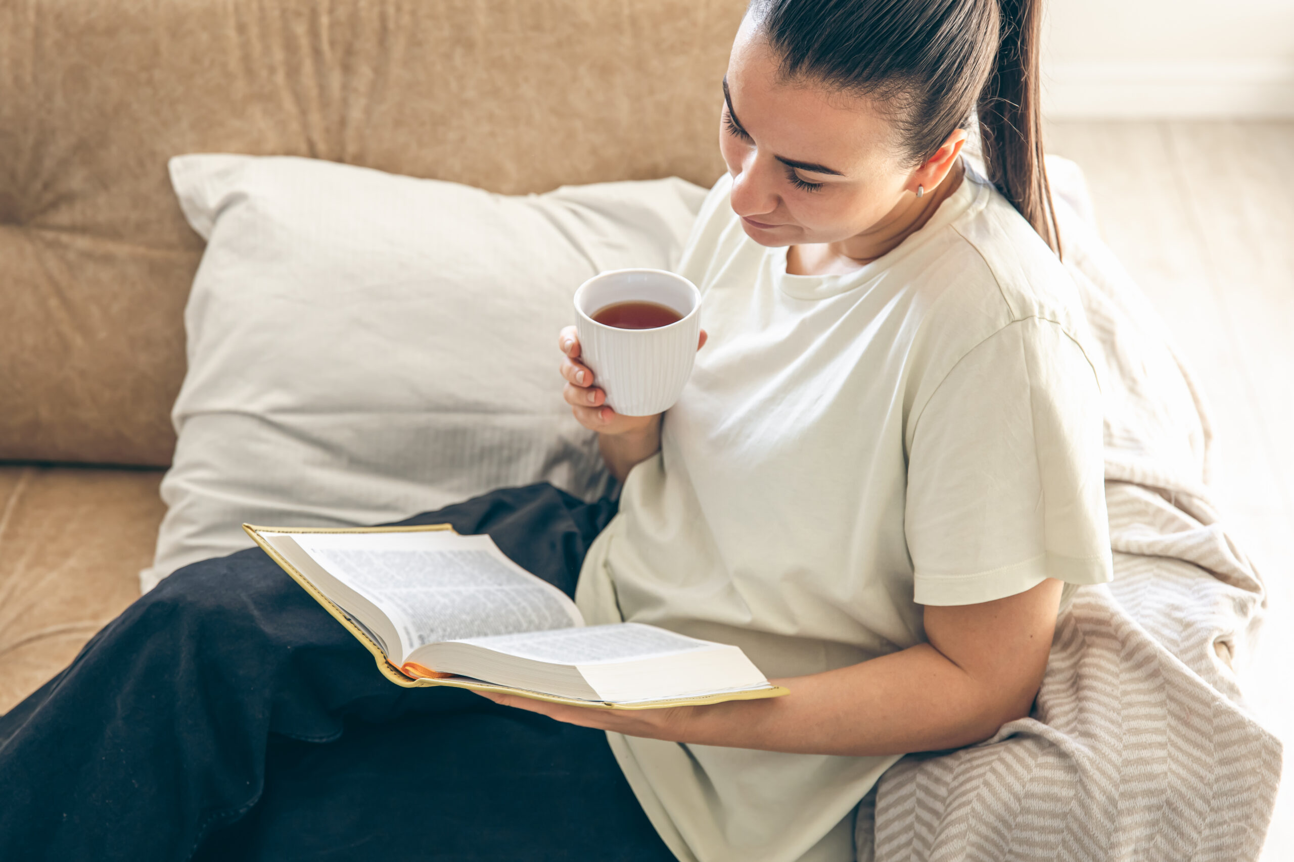 Persona leyendo un libro en casa